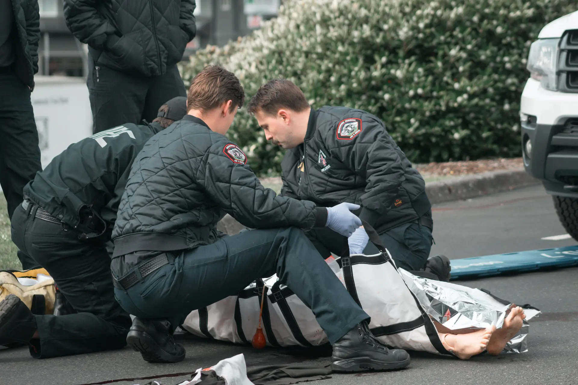 paramedics helping injured person on ground