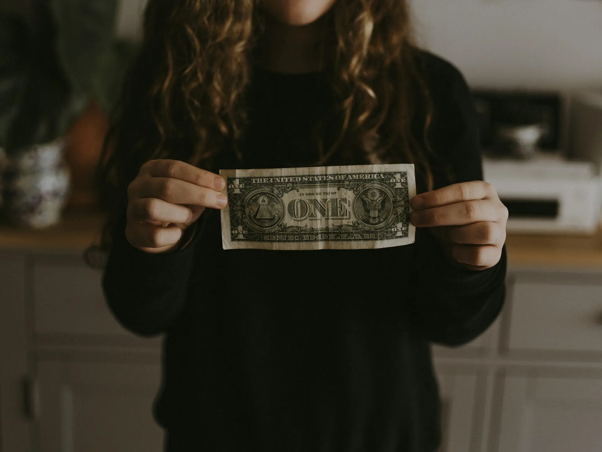 woman holding a dollar - who pays in a personal injury claim