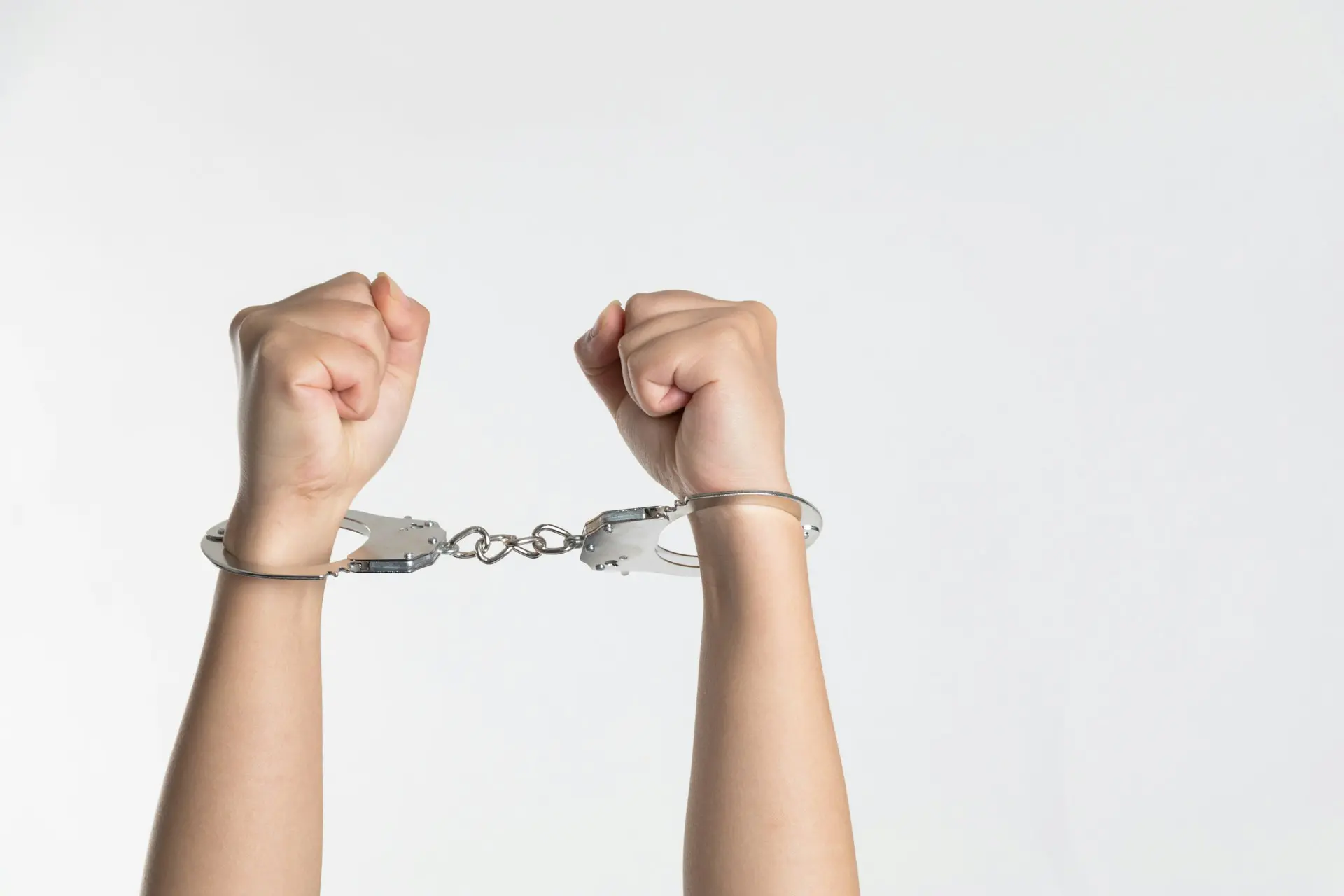handcuffed wrists against white background