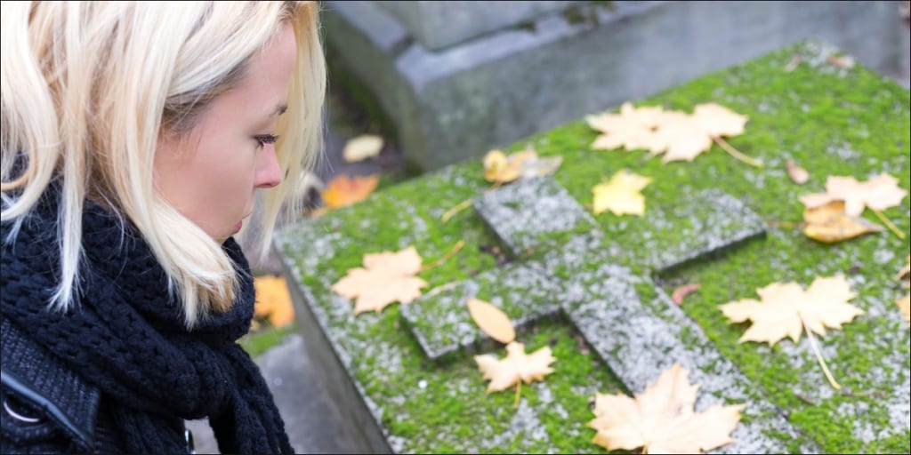 woman standing over grave of wrongful death individual