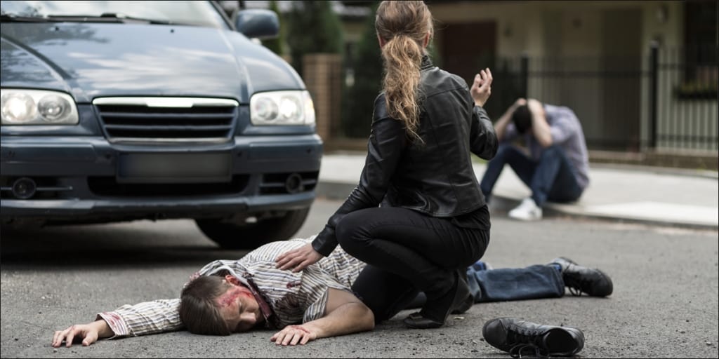 women helping pedestrian hit by car in accident