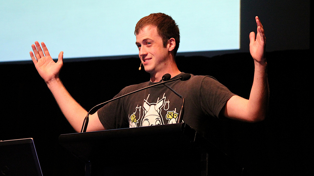 man pubic speaking at a panel