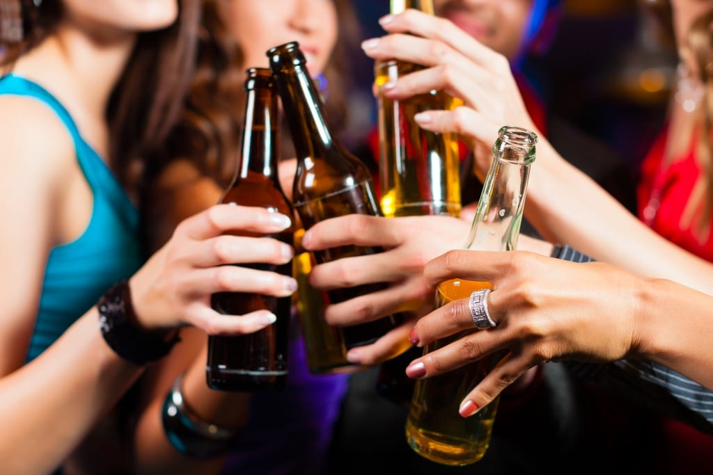 a group of women cheersing beers