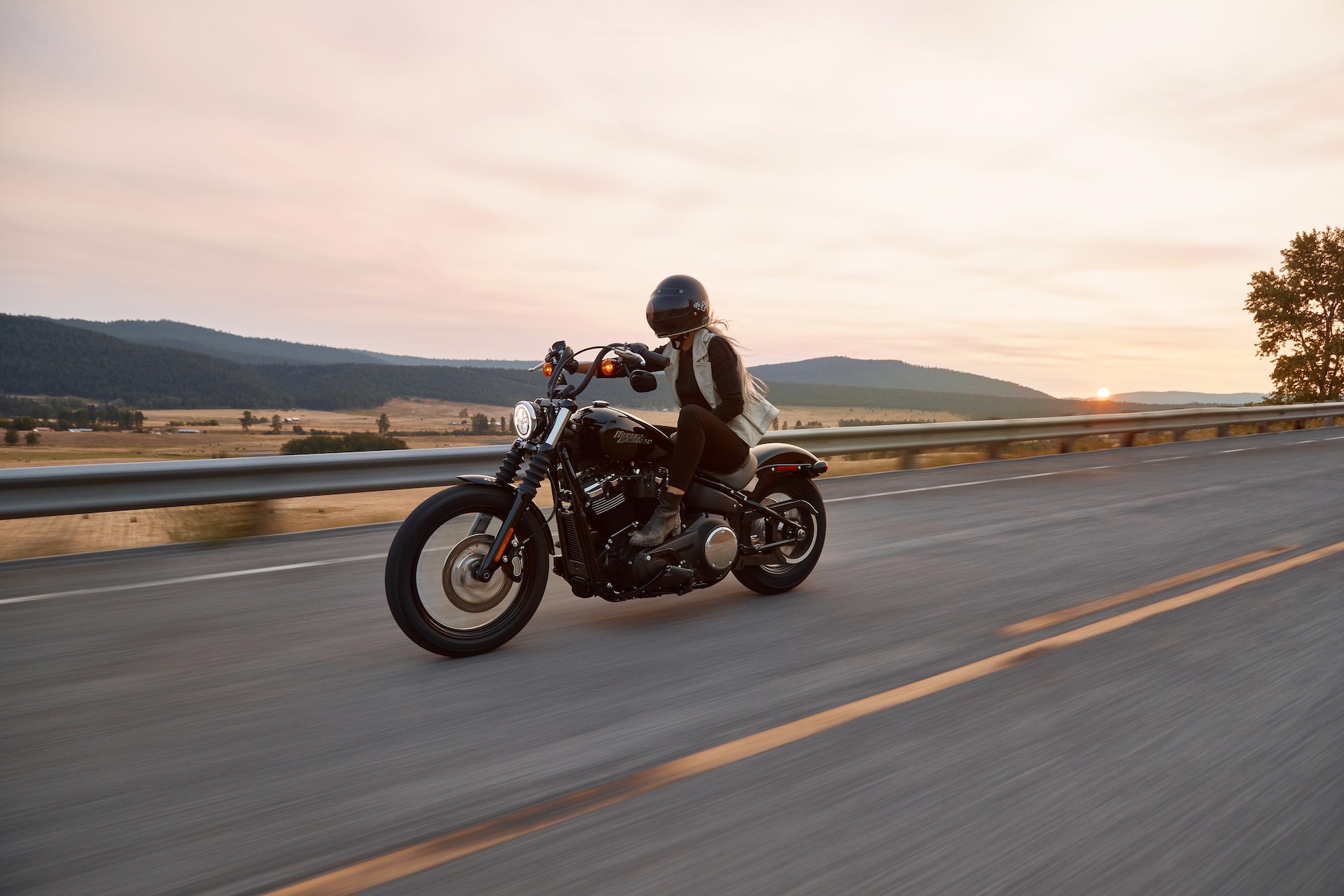 woman driving motorcycle at sunset