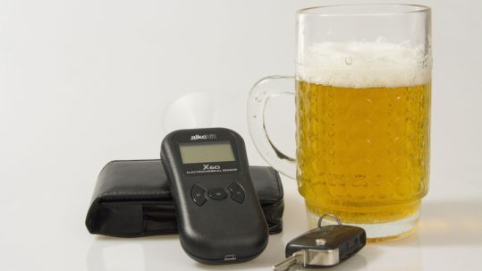 breathalyzer, car keys, and beer on tabletop