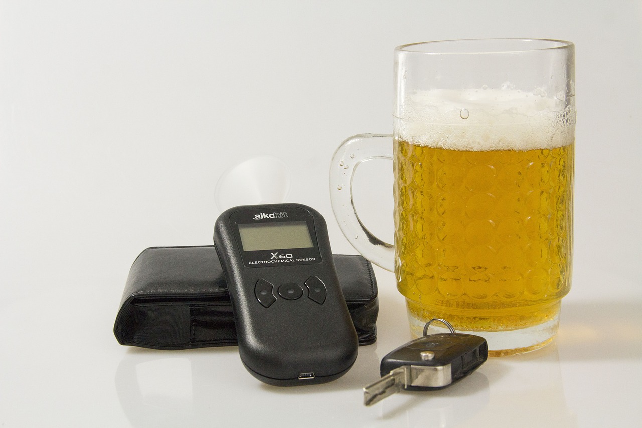 breathalyzer, car keys, and beer on tabletop