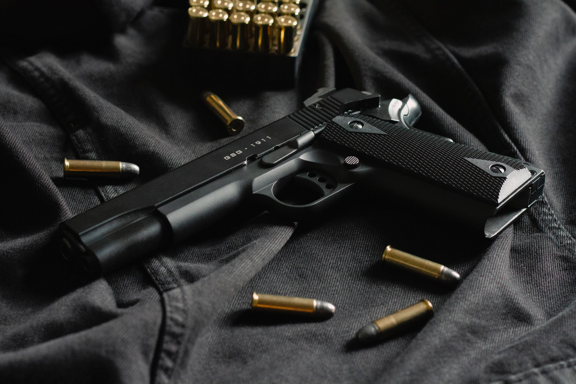 gun in car arizona; gun and bullets on black background