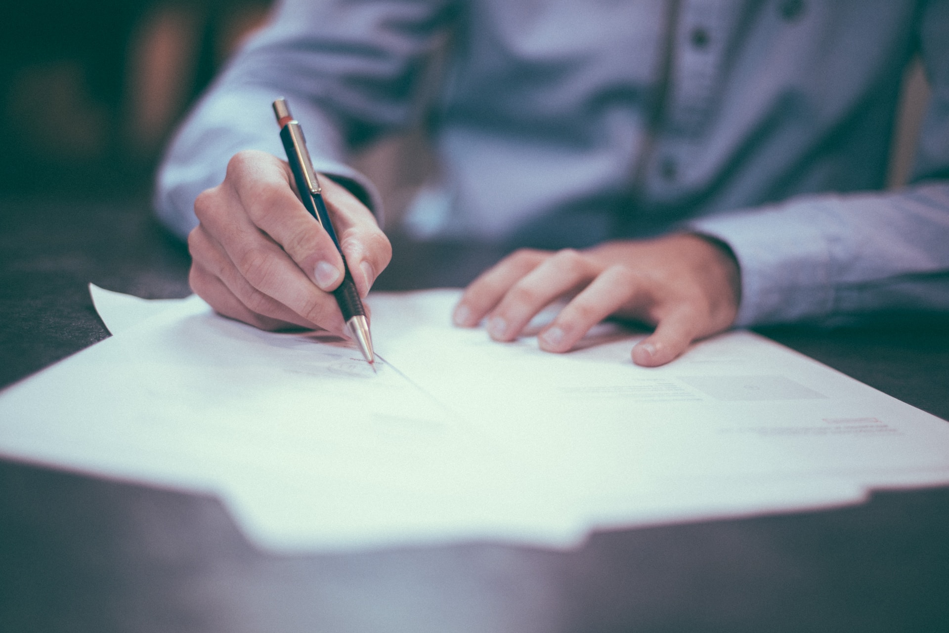 person sitting with many papers - types of forgery